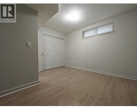 A bedroom with a white door and a window with blinds.