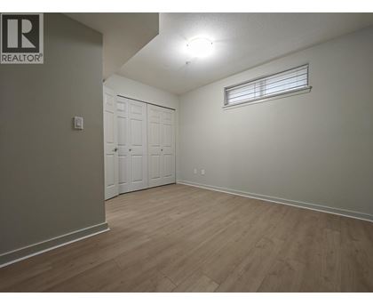 A bedroom with a white door and a window with blinds.
