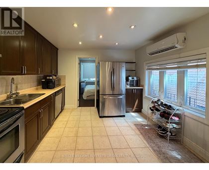 A kitchen with a refrigerator, sink, and oven.
