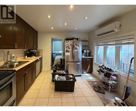 A kitchen with a refrigerator, sink, and oven.