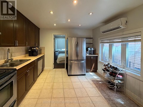 A kitchen with a refrigerator, sink, and oven.