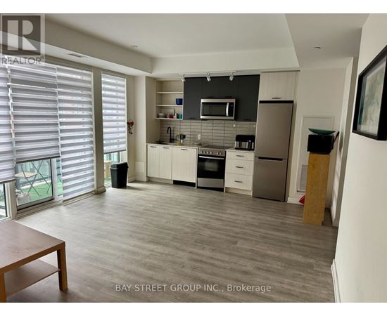 A kitchen with a dining table and a refrigerator.