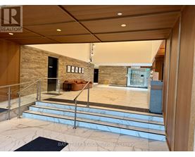 A spacious lobby with a staircase and a couch.