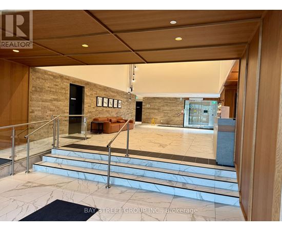 A spacious lobby with a staircase and a couch.