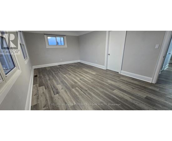 A room with wood flooring and a window.