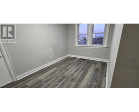 A room with a window and a wooden floor.
