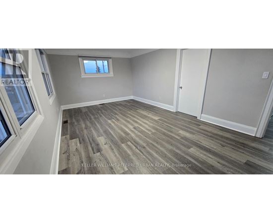 A room with wood flooring and a window.