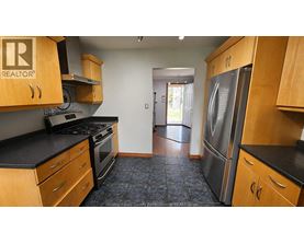A kitchen with wooden cabinets and a black countertop.