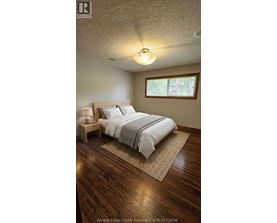 A bedroom with a bed, nightstand, and window.