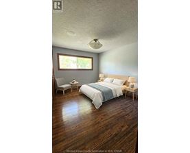 A bedroom with a bed, chair, and table.