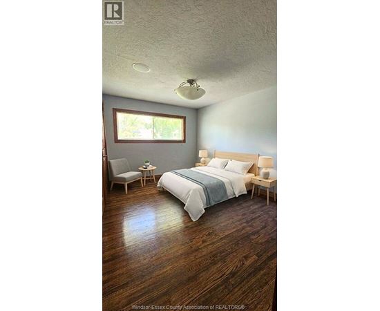 A bedroom with a bed, chair, and table.