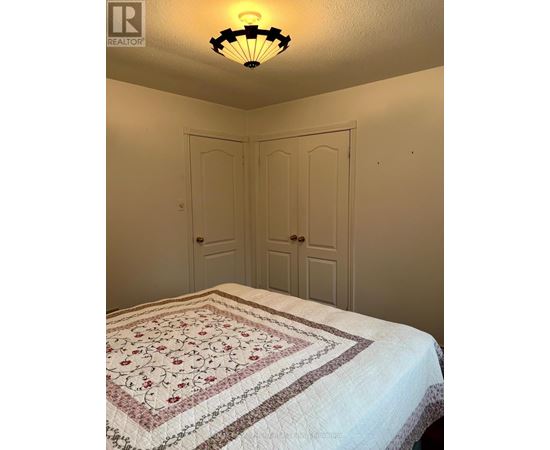 A bedroom with a bed and two doors.