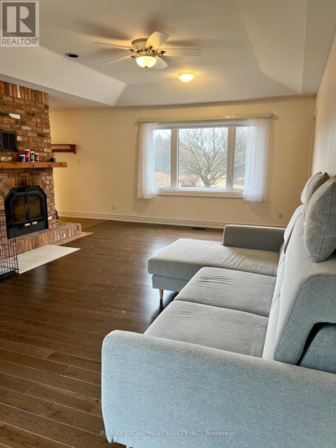 A living room with a grey couch and a fireplace.
