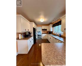 A kitchen with white cabinets and a wooden floor.