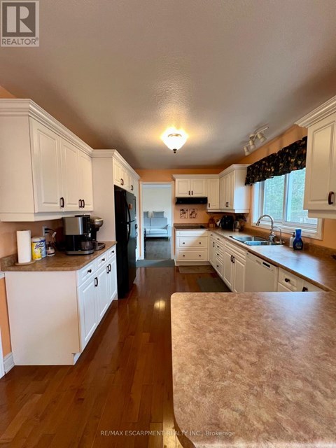 A kitchen with white cabinets and a wooden floor.