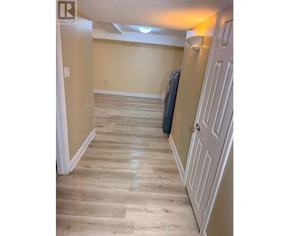 A hallway with a white door and a wooden floor.