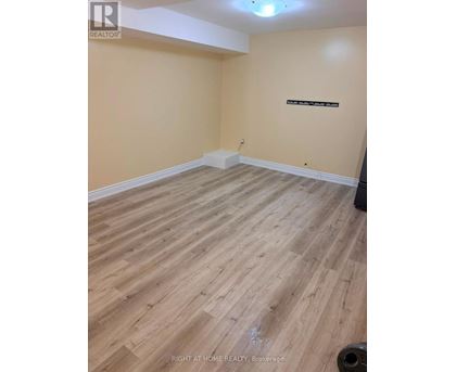 A room with wooden flooring and a wall-mounted sign.