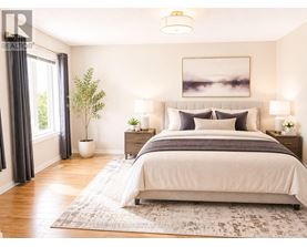 A well-lit bedroom with a large bed and a framed picture on the wall.