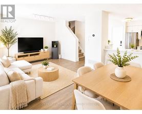 A living room with a couch, a television, and a dining table.