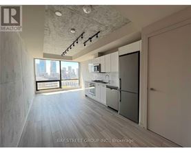 A spacious kitchen with white appliances and a view of the city.