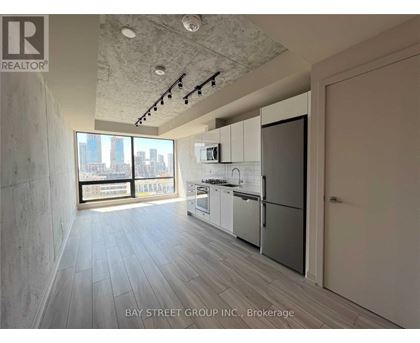 A spacious kitchen with white appliances and a view of the city.