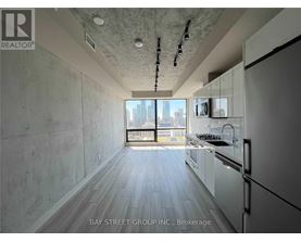 A modern kitchen with white cabinets and a view of the city.