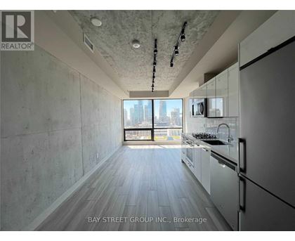 A modern kitchen with white cabinets and a view of the city.