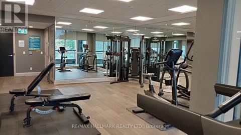 A gym with a variety of equipment including treadmills, weights, and exercise machines.