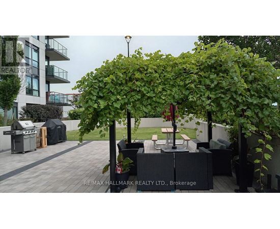 A patio area with a table and chairs under a tree.