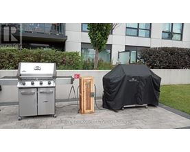 A grill and a covered table are set up outside a building.