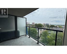 A balcony with a glass railing and a view of the city.