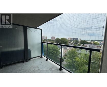 A balcony with a glass railing and a view of the city.