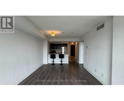 A spacious room with a desk and chairs in the middle.
