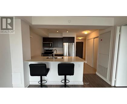 A modern kitchen with a bar stool and a counter.