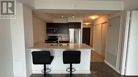 A modern kitchen with a bar stool and a counter.