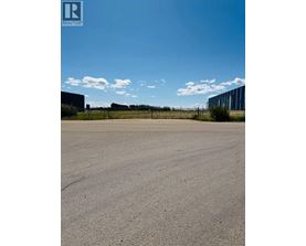 A large, empty parking lot with a clear sky above.