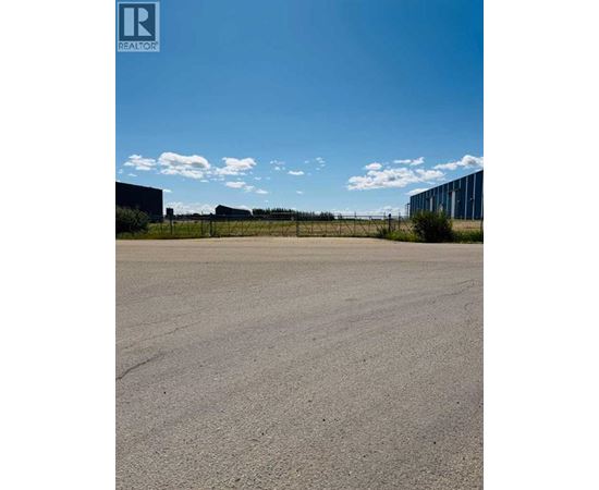 A large, empty parking lot with a clear sky above.