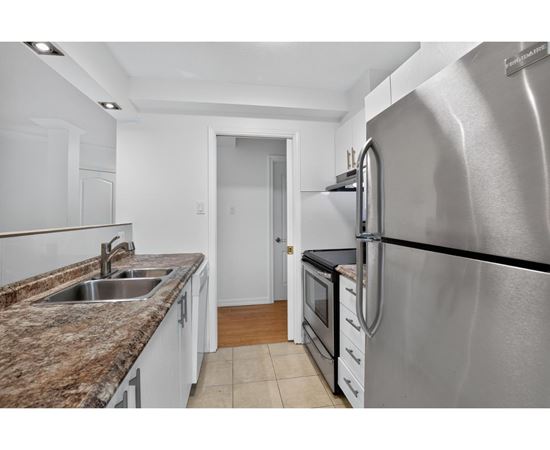 A kitchen with a granite countertop and stainless steel appliances.