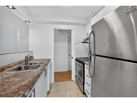 A kitchen with a granite countertop and stainless steel appliances.