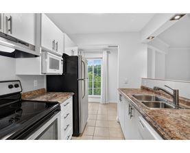 A kitchen with black appliances and granite countertops.