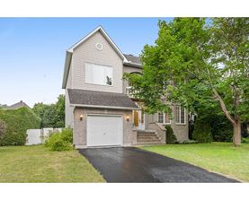 A two-story house with a garage and a driveway.