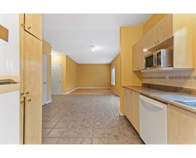 A kitchen with wooden cabinets and a tiled floor.