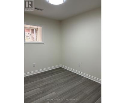 A room with a window and a wooden floor.