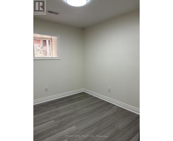 A room with a window and a wooden floor.