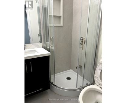 A bathroom with a toilet, sink, and shower.