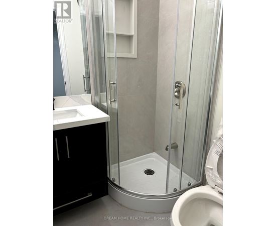 A bathroom with a toilet, sink, and shower.