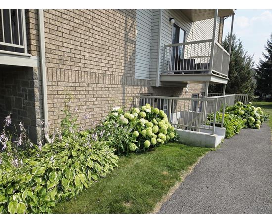 A building with a balcony and a gravel path in front.
