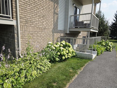 A building with a balcony and a gravel path in front.