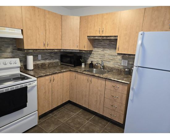A kitchen with wooden cabinets and a white refrigerator.