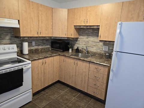 A kitchen with wooden cabinets and a white refrigerator.